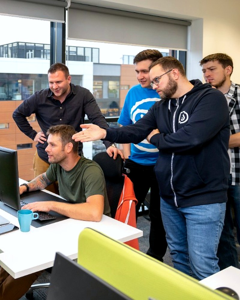 Profesjonalny zespół podczas współpracy przy laptopie w nowoczesnym biurze